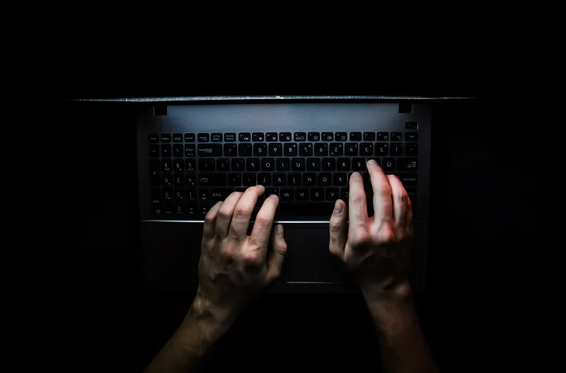 Ett tagentbord på en laptop i ett mörkt rum.